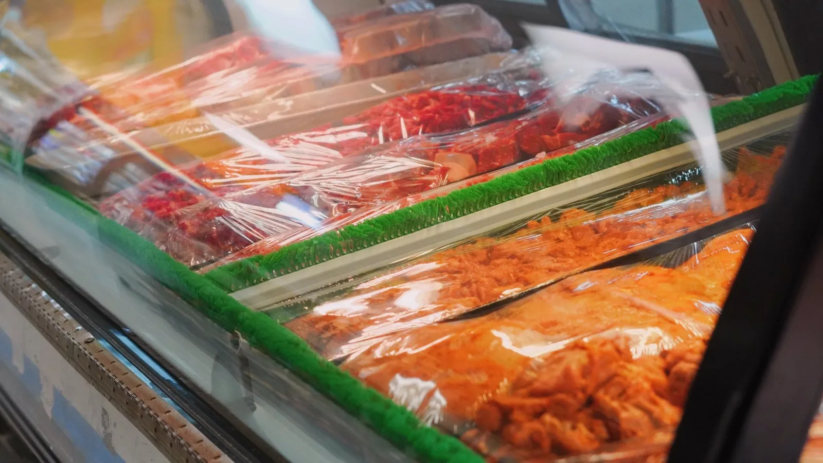 Fresh seasoned meats displayed at the meat counter inside Taqueria Market Portland
